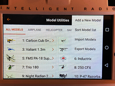 A picture of the transmitter. The 'Model Utilities' screen is viewable.